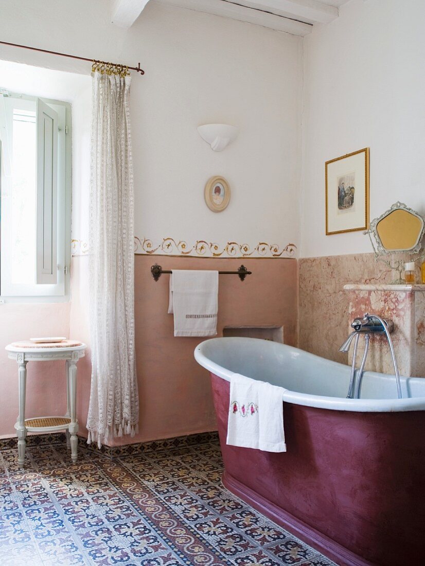 Bathroom with free-standing bathtub and cement mosaic tiles in Tuscan country house