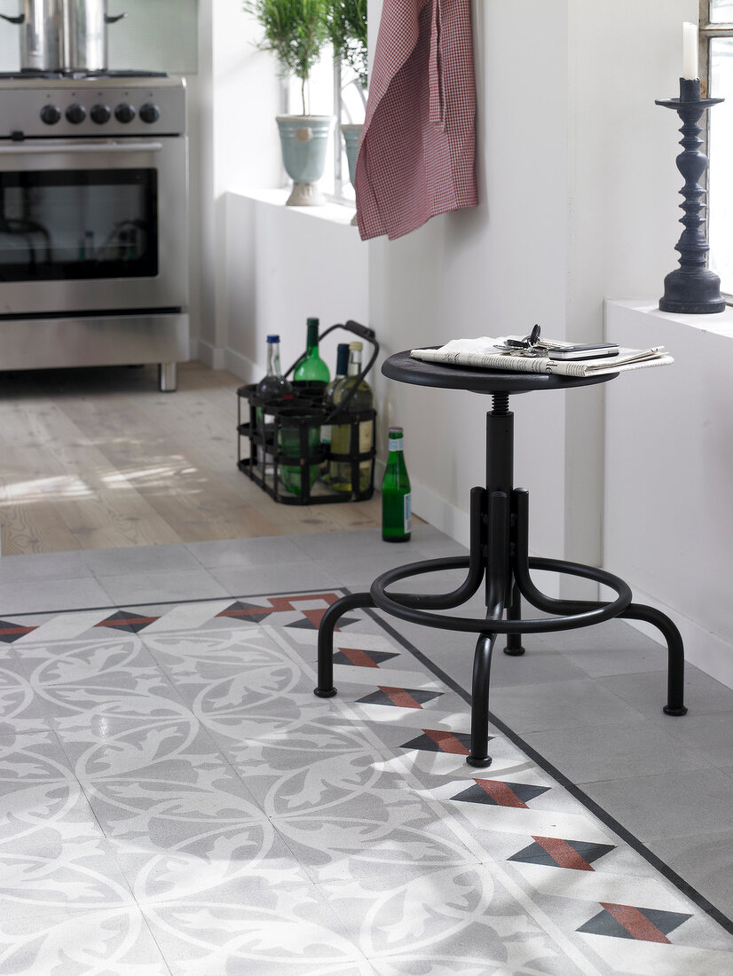 Mosaic and terrazzo tiled floor with chair on side