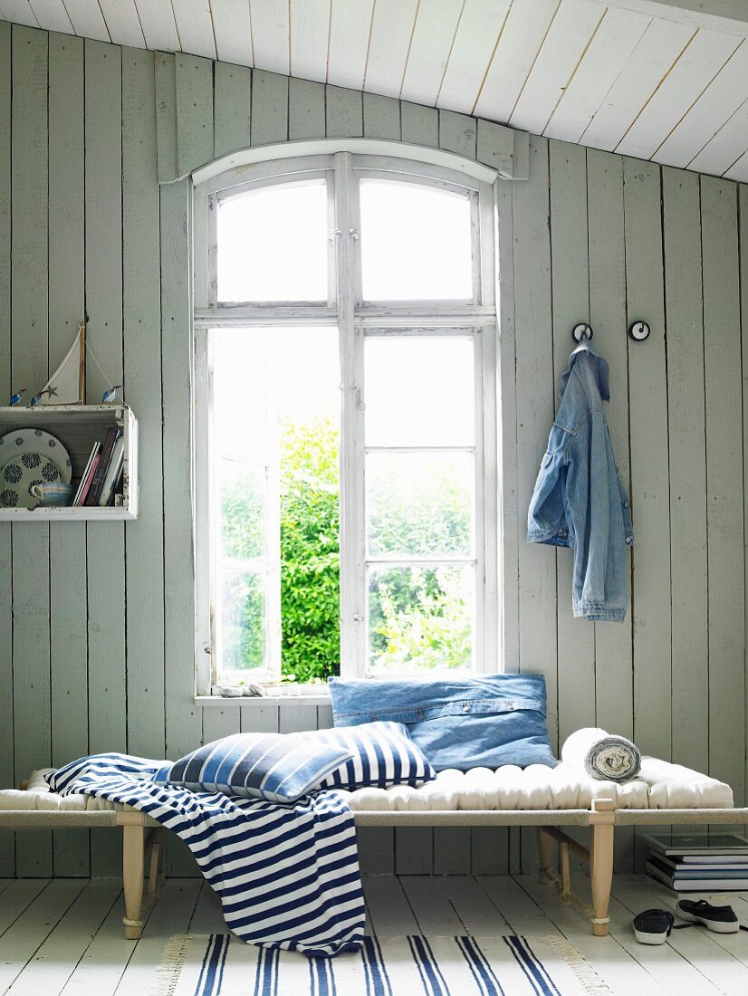 Maritime ambiance; lounger with beech frame and linen-covered mattress below window