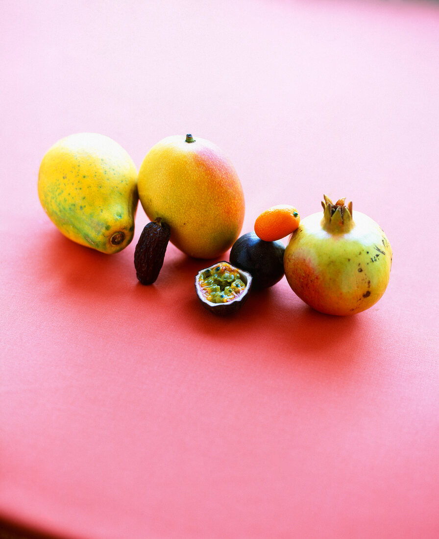 Papaya, mango, permanganate and half passion fruit on red background