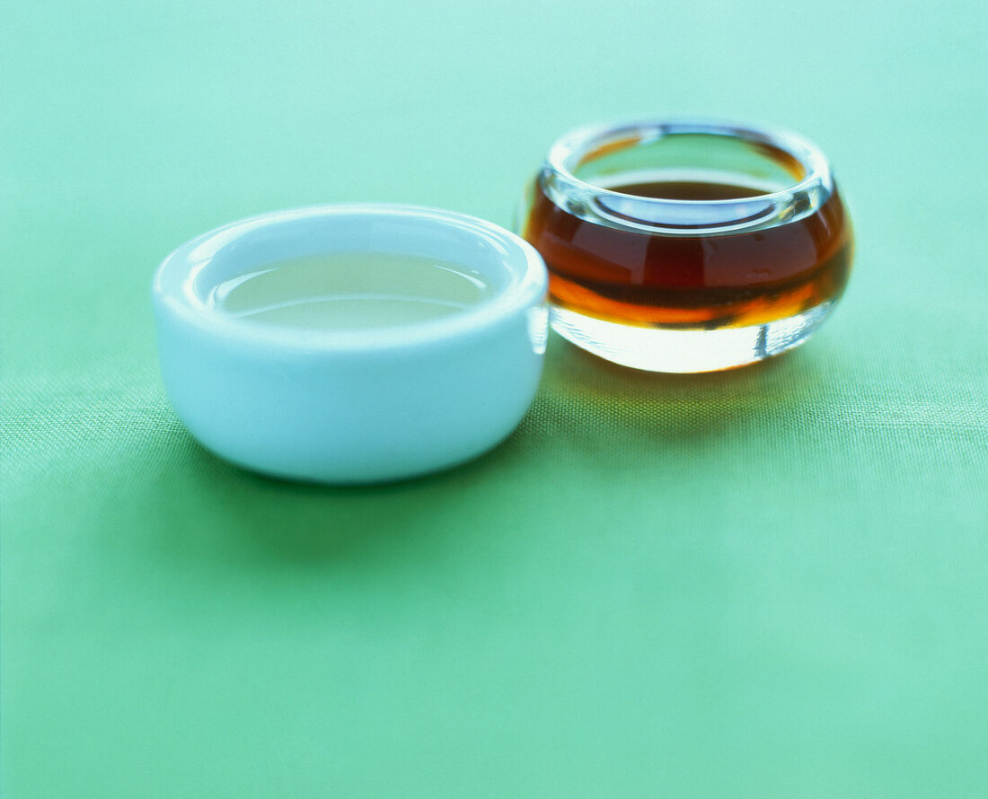 Sesame oil and peanut oil on green background