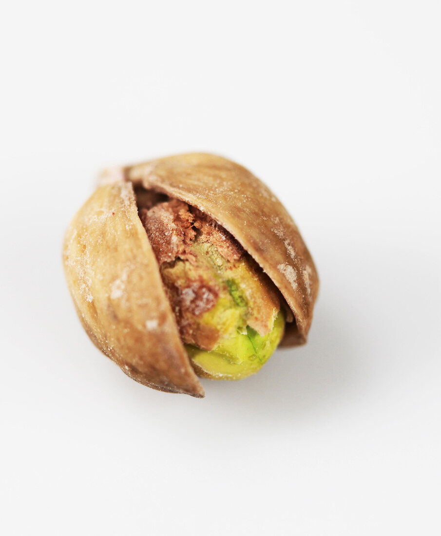 Pistachio in broken shell on white background