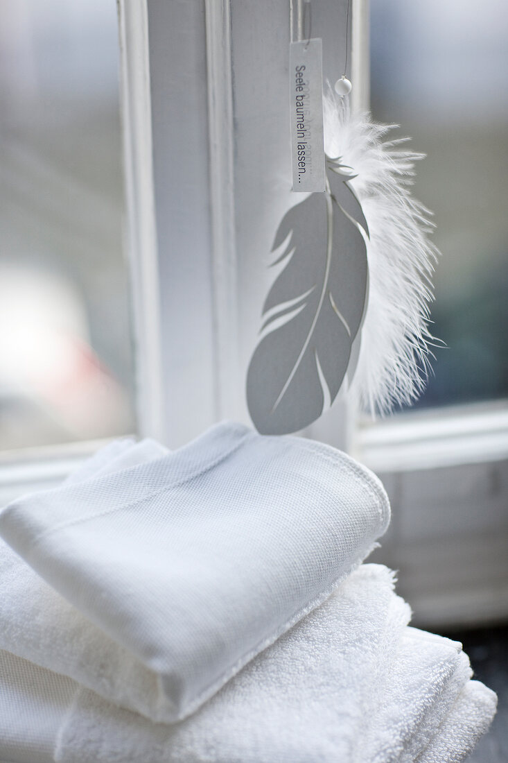 Close-up of white towel with feather