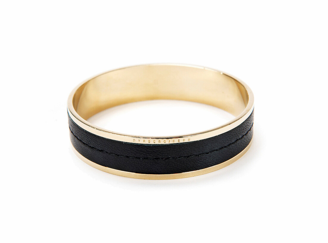 Close-up of gold and black bangle on white background