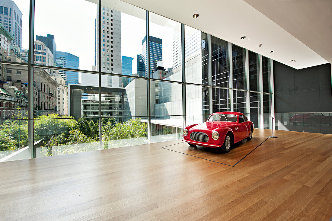 View of Museum of Modern Art with red car overlooking city, New York, USA