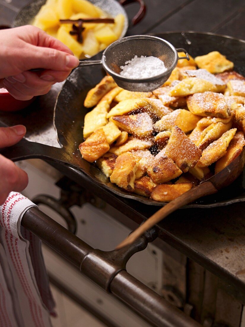 Kaiserschmarren (shredded sugared pancake from Austria) being dusted with icing sugar