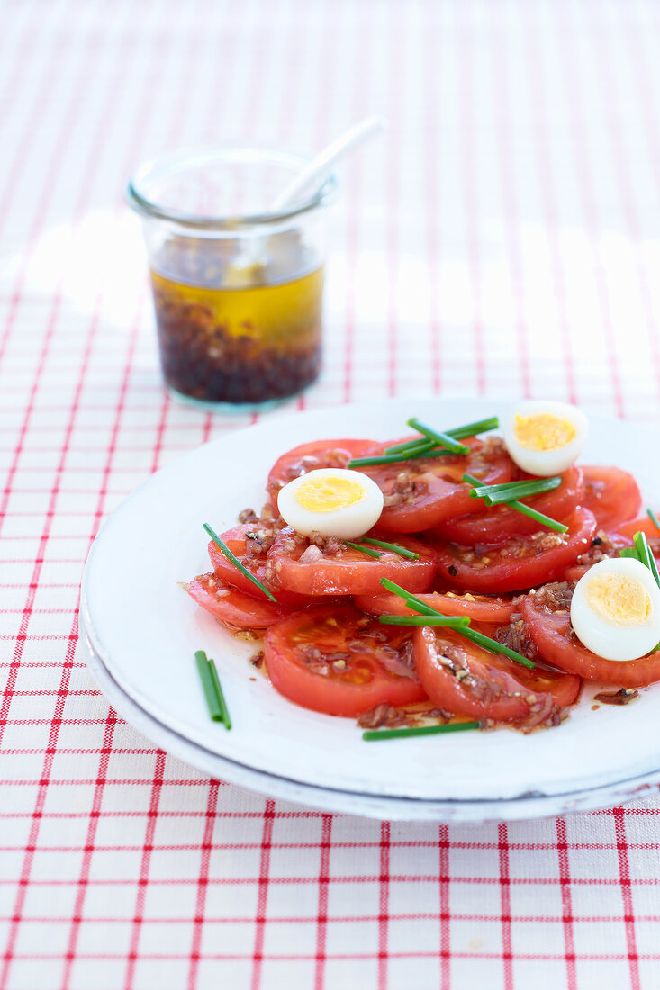 Tomato salad with hard-boiled quail eggs on plate