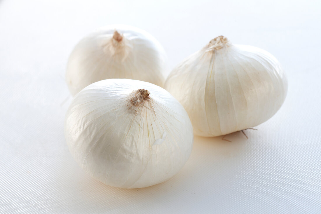Close-up of white onions on white background