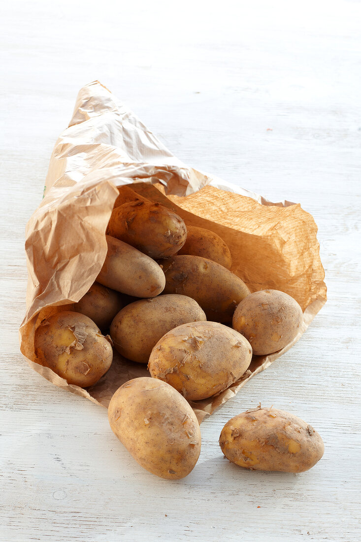 Brown paper bag with unwashed potatoes