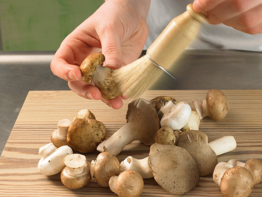 Mushrooms being cleaned with brush, step 1
