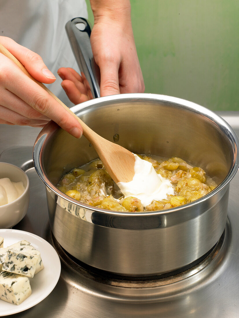 Stirring cream with mixture for preparation of gooseberry confit, step 3