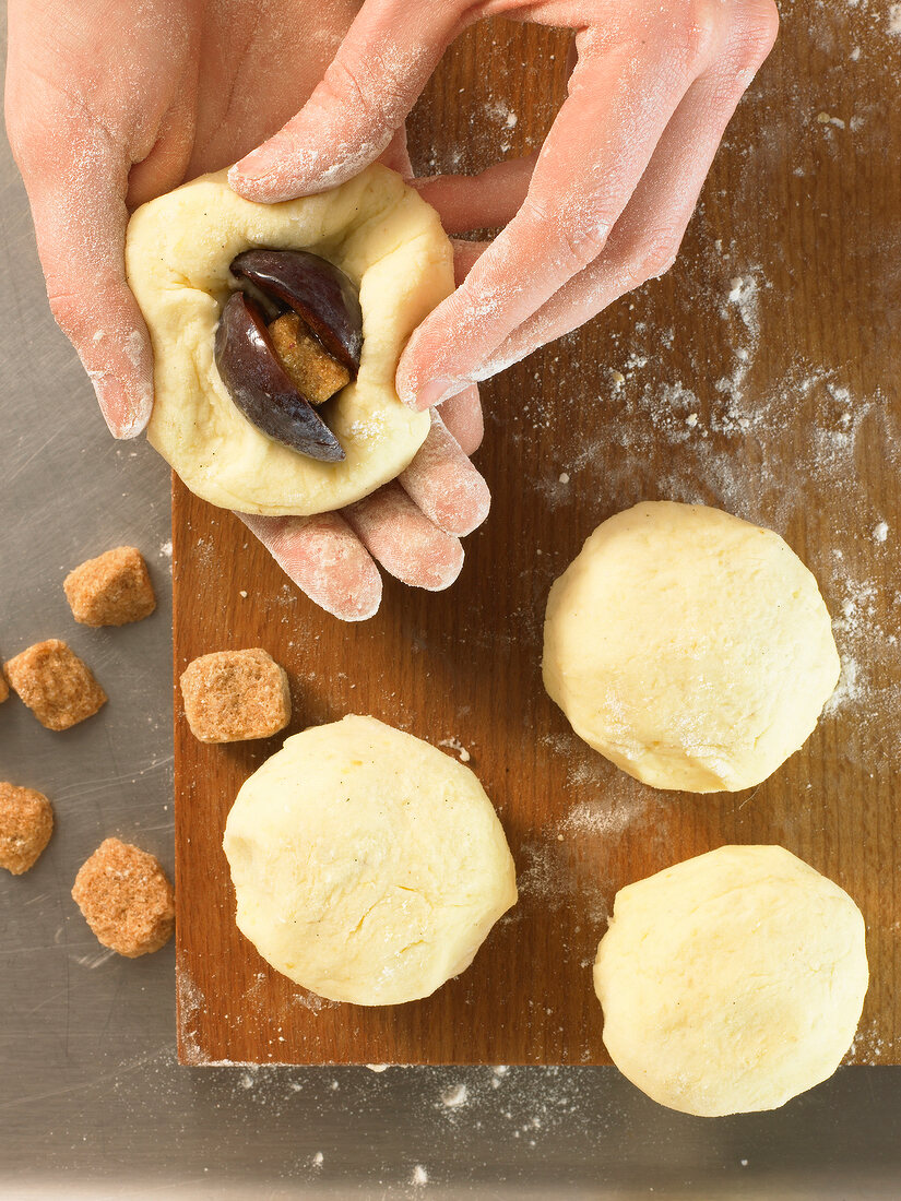 Folding dough with plum for preparation of plum dumpling, step 2