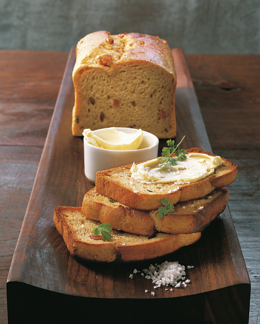 Rye bread with potatoes, bacon, butter and salt on wooden surface