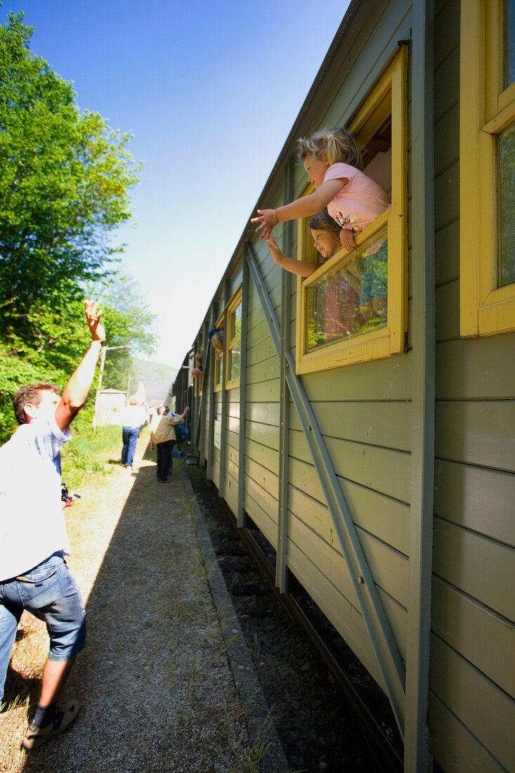 Children waving out of train window in Franconian Switzerland, Bavaria, Germany