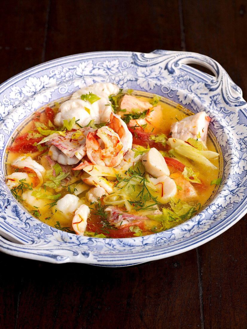 Close-up of bouillabaisse with saffron and garlic bread in serving dish