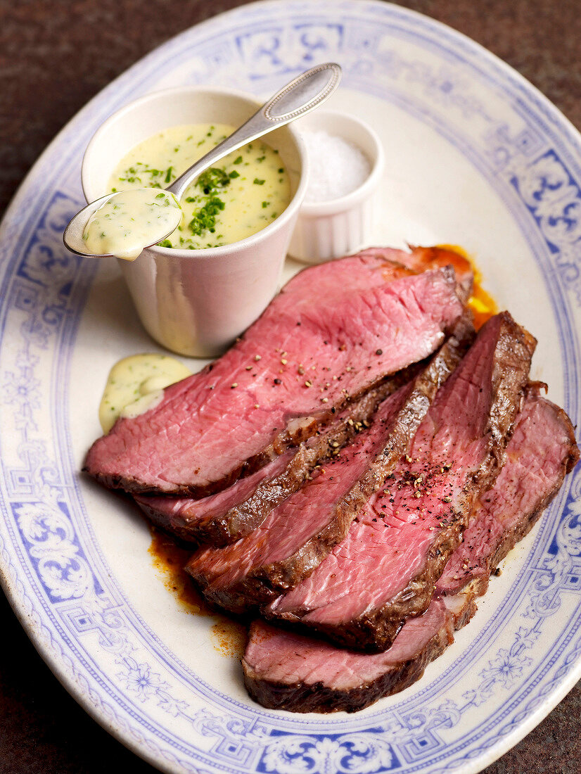 Close-up of roast beef with bearnaise sauce on plate
