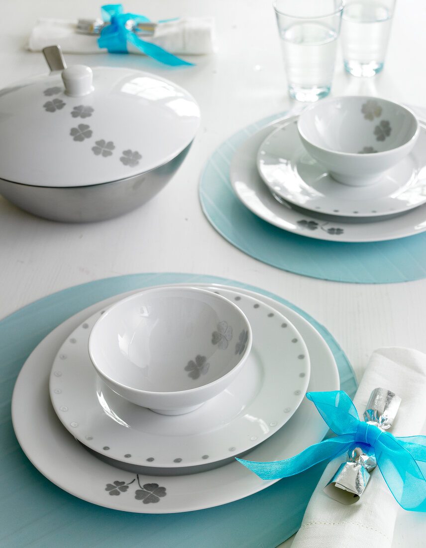 White painted porcelain tableware on blue table mat