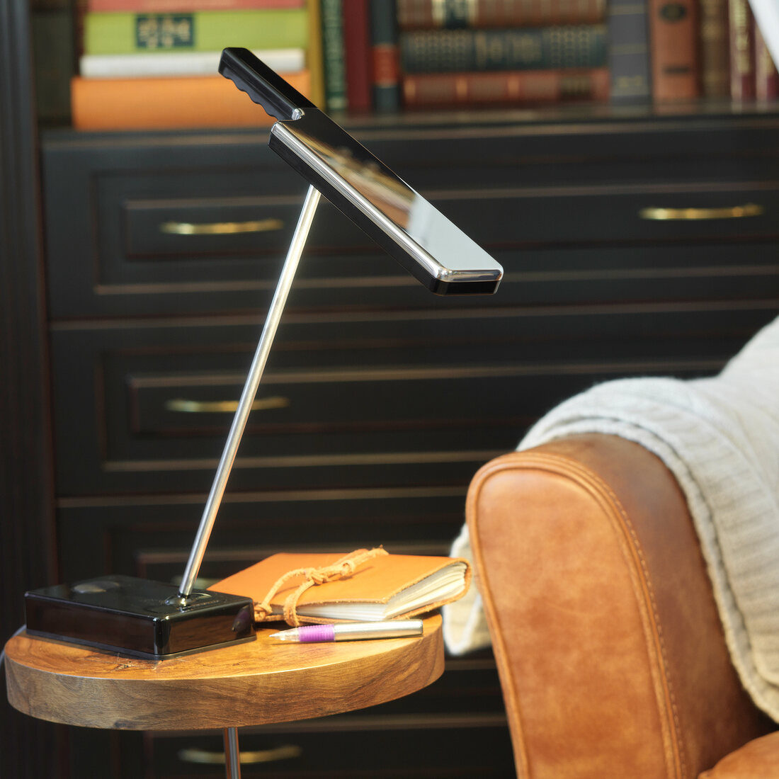 Side table with reading lamp and book next to armchair