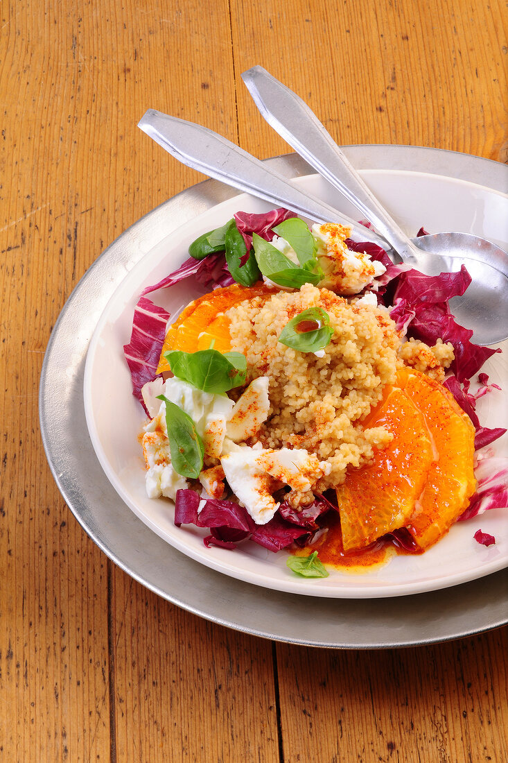 Couscous salad with blood oranges and feta cheese on plate