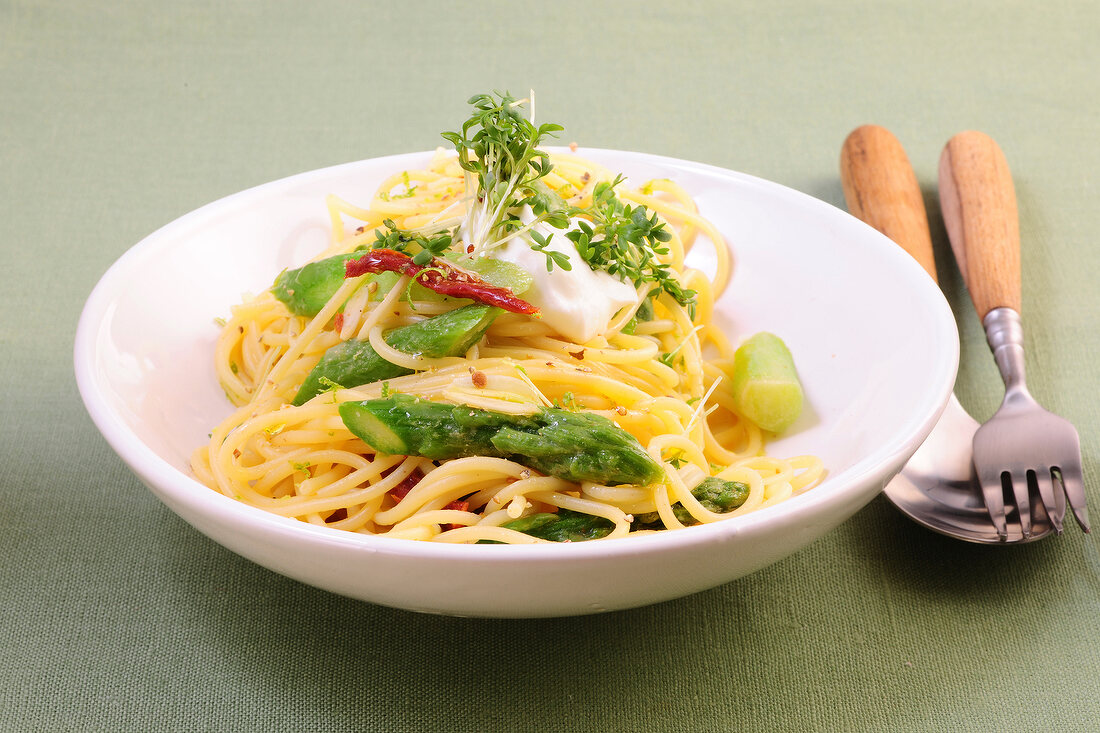 Pasta with green asparagus and fresh goat cheese in bowl
