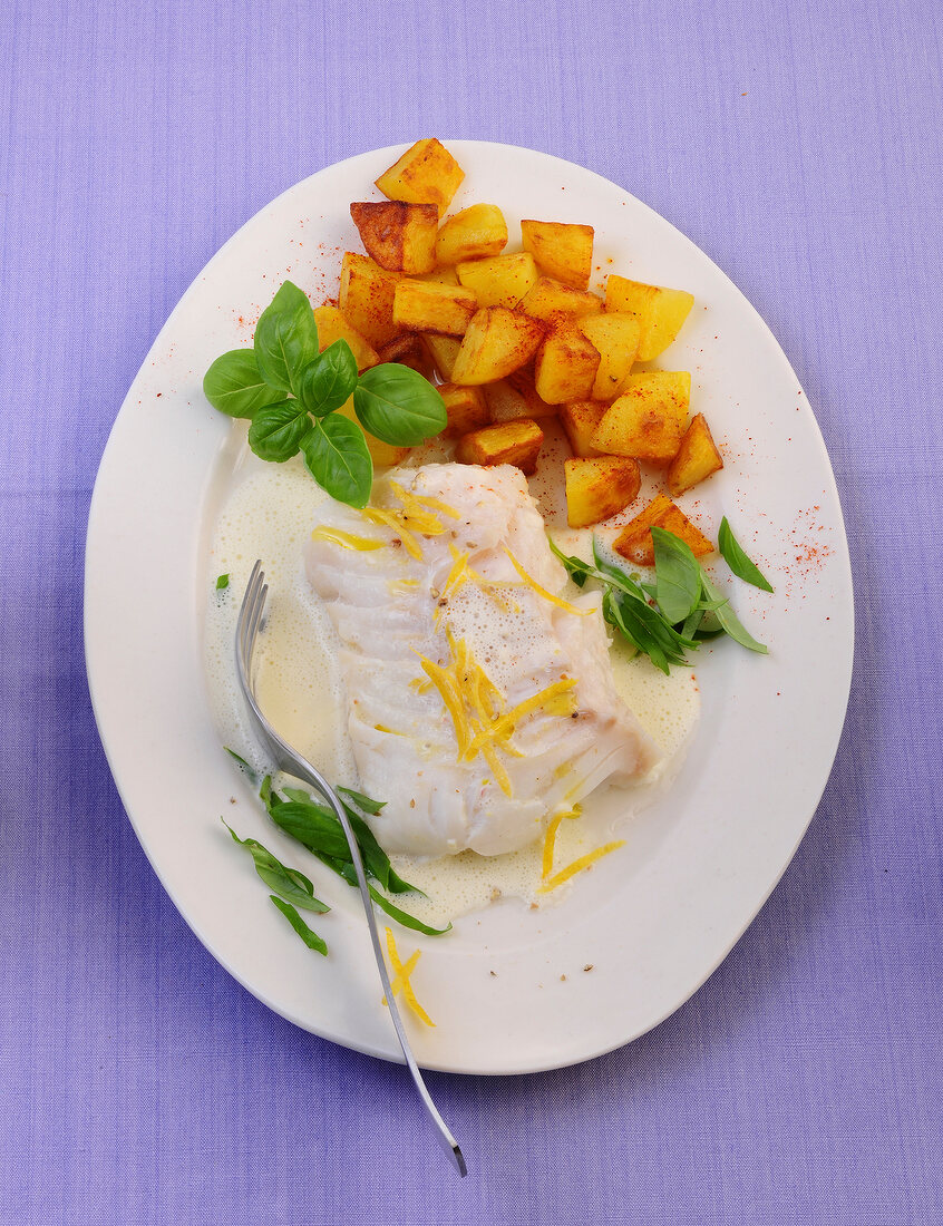 Cod with basil cream and diced potatoes in serving dish