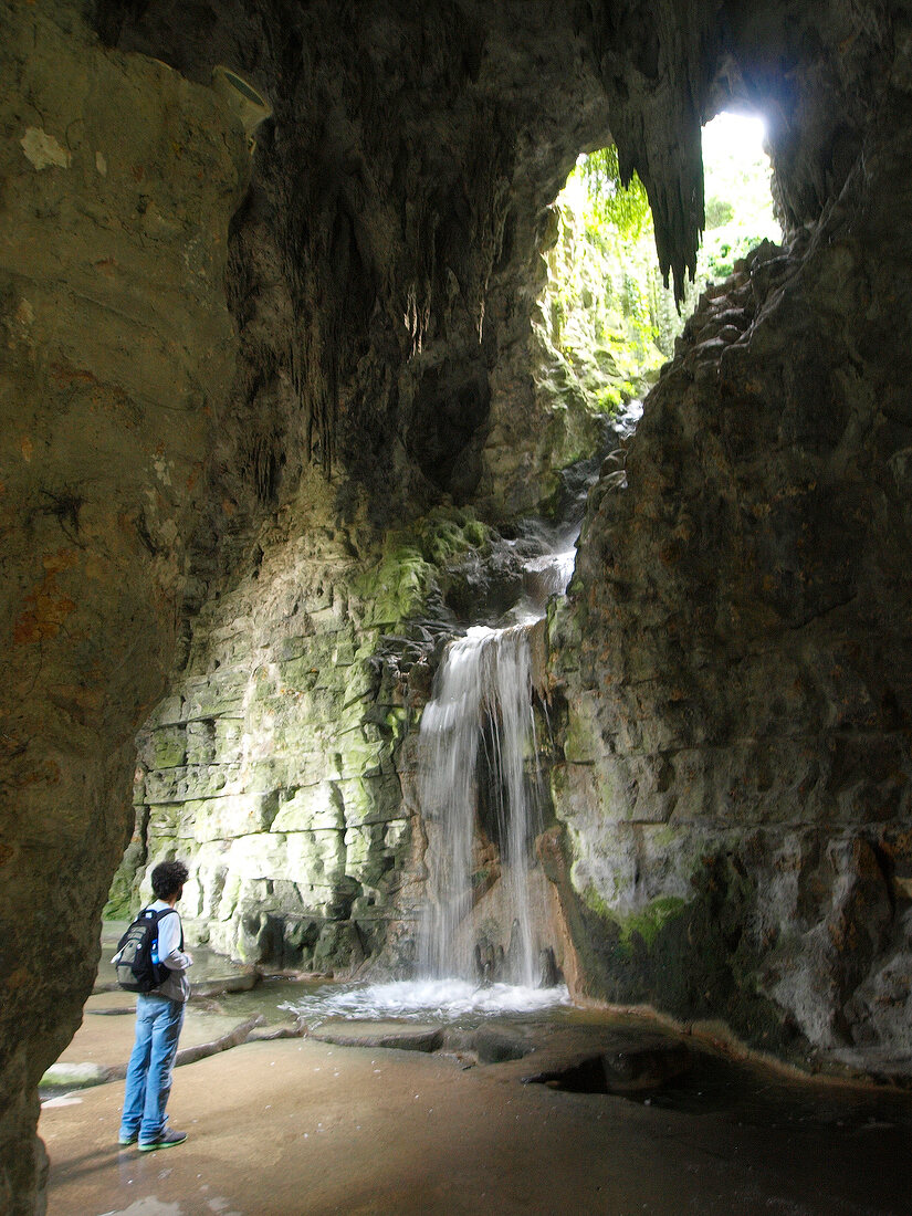 Man standing in artificial grotto, Parc des Buttes-Chaumont, Paris, France