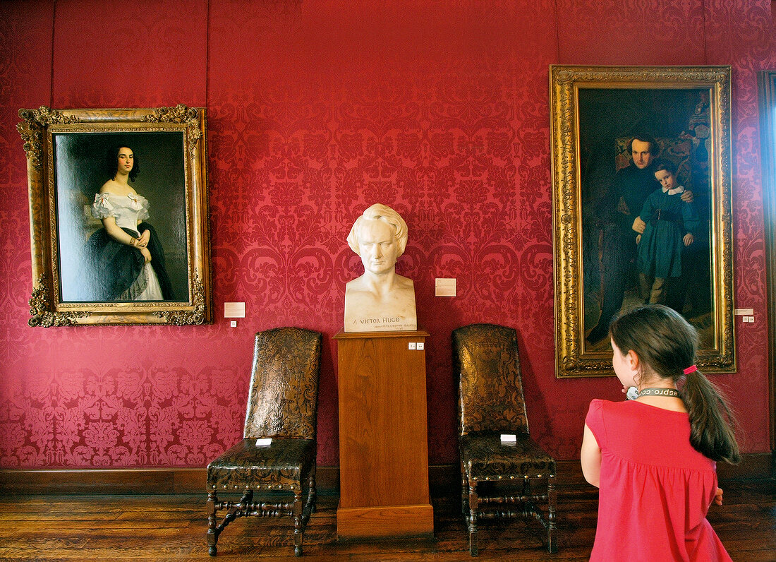 Visitor looking at Bust of Victor Hugo in Louvre museum, Paris, France