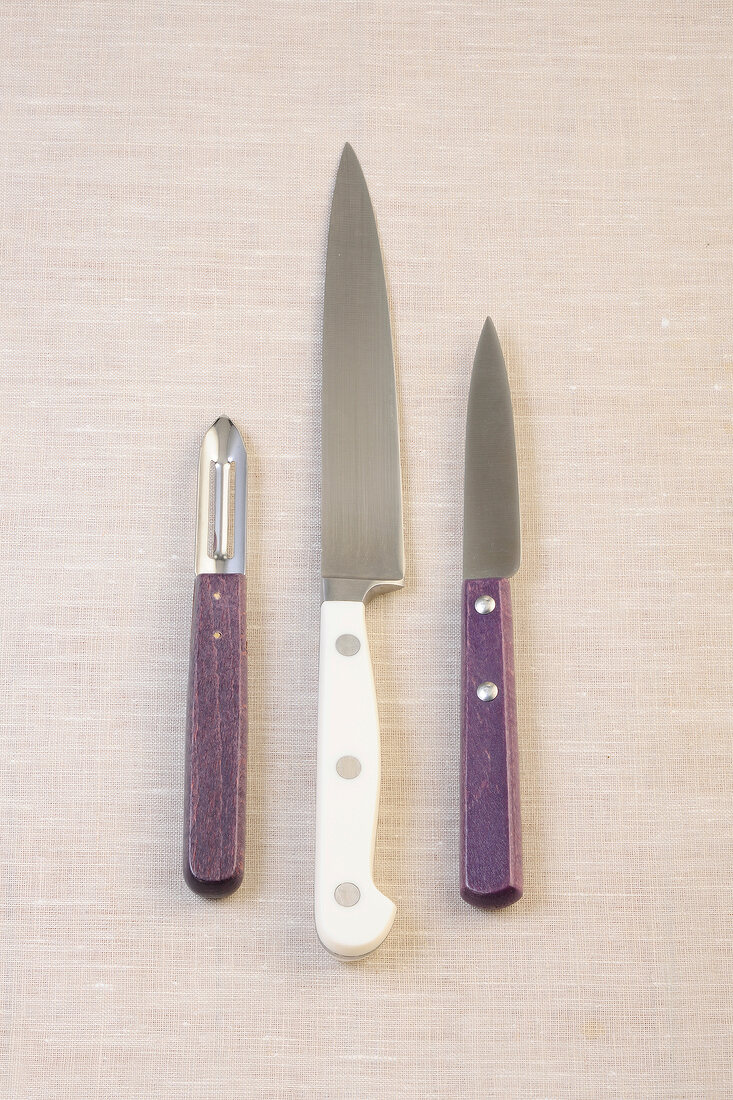 Two knife with peeler on beige background