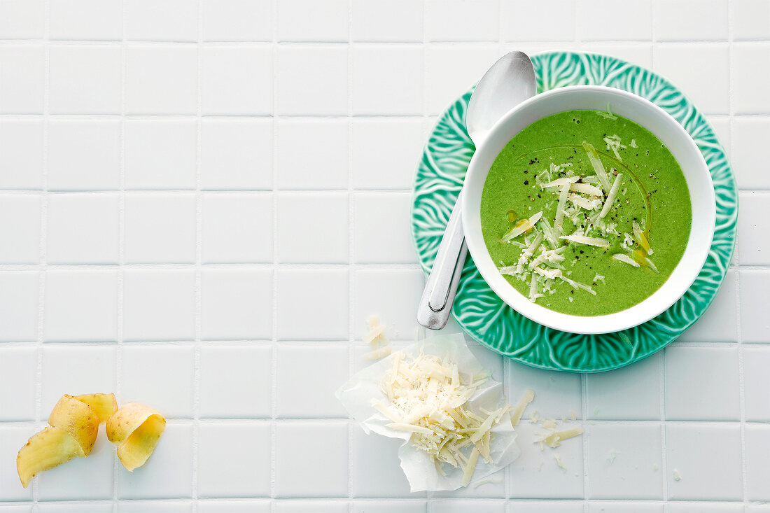 Potato and spinach soup with parmesan in bowl