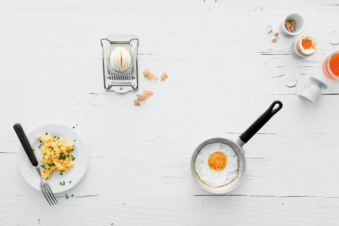 Four egg dishes on plate, pan and various containers