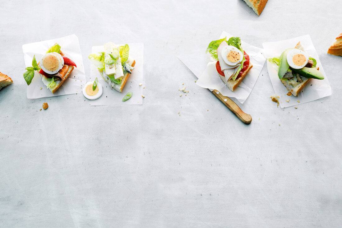 Four different egg sandwiches on baking paper