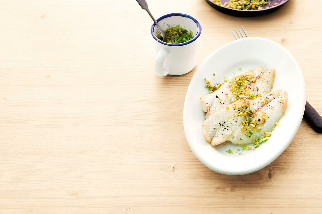 Fish with garlic and nut crust in serving dish