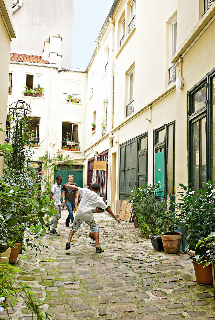 Boys playing football on street in Paris, France