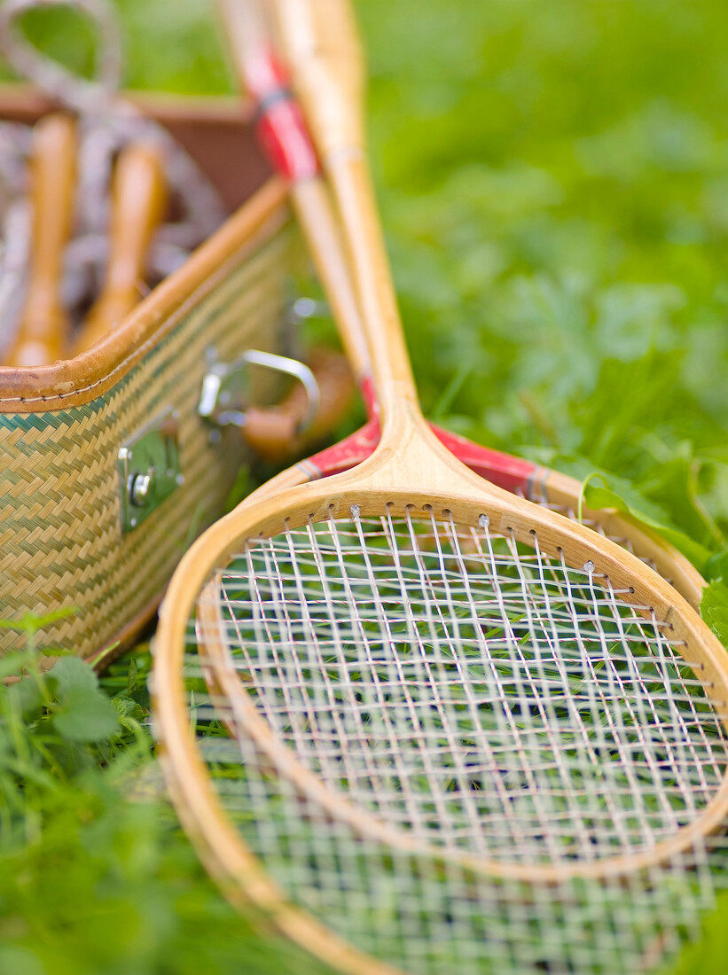 Close-up of two badminton rackets lying on grass