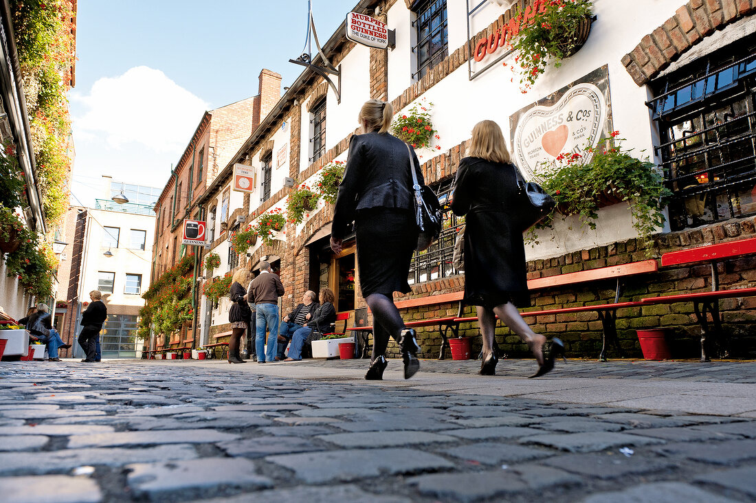 Low angle view of people walking through Cathedral Quarter pubs, Belfast, Ireland