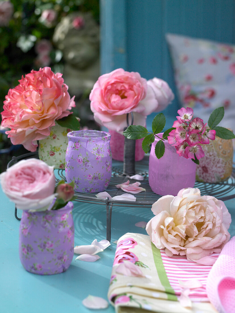 Fresh roses in floral patterned vases