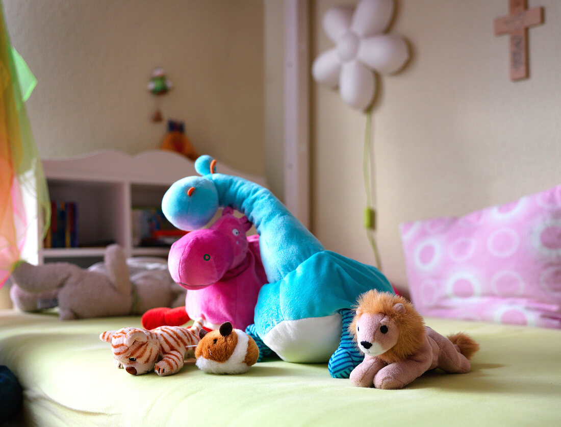 Various soft toys on bed in children's room