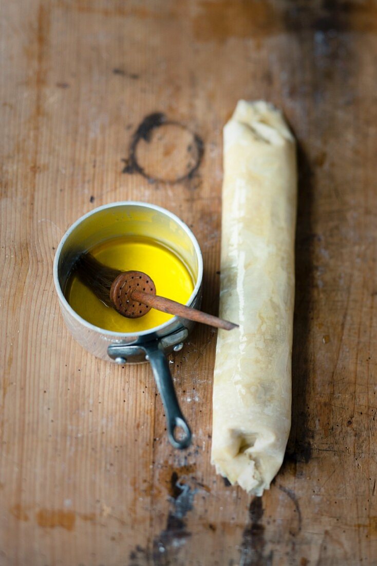 Apfelstrudel zubereiten: Filoteig mit Butter bepinseln