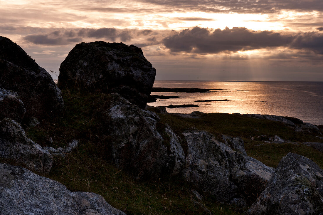 View of rocky coast overlooking sea at sunset in Fanad, Ireland