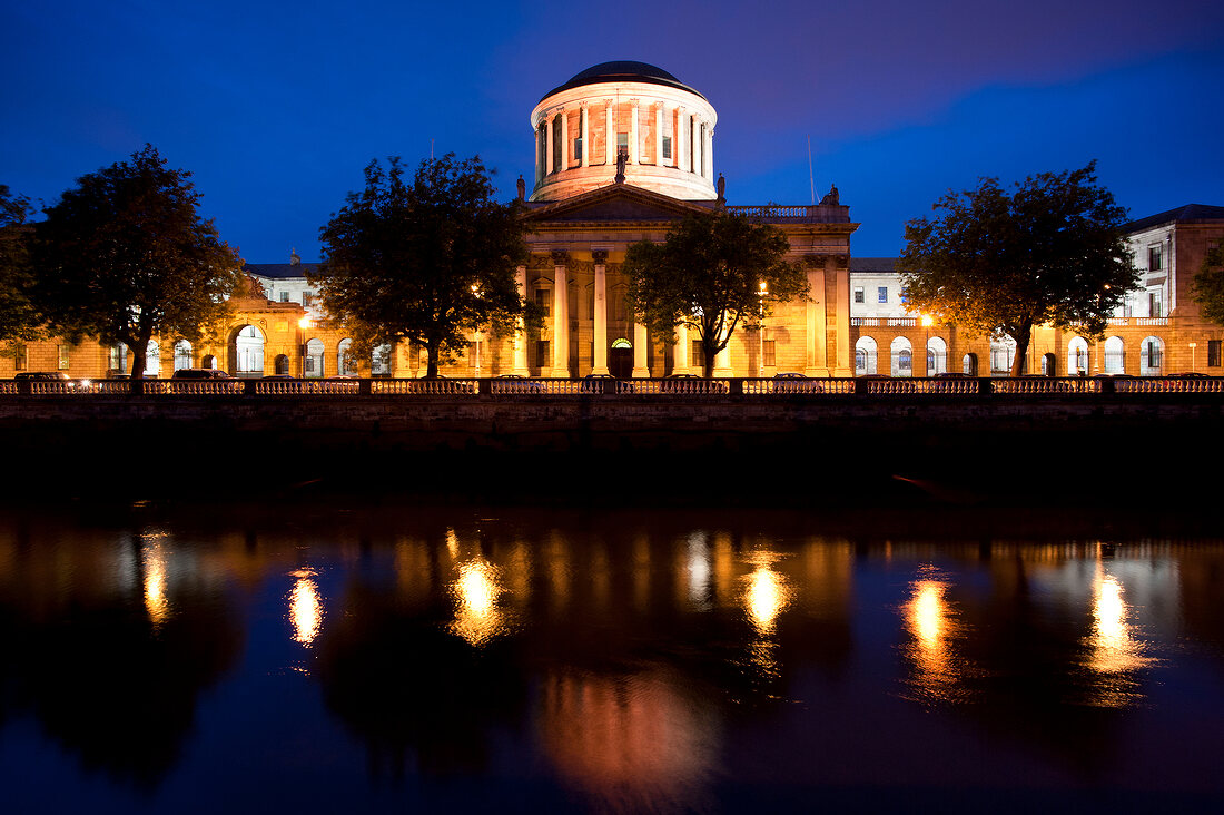 View of illuminated Four Courts and River Liffey at night, Dublin, Ireland, UK