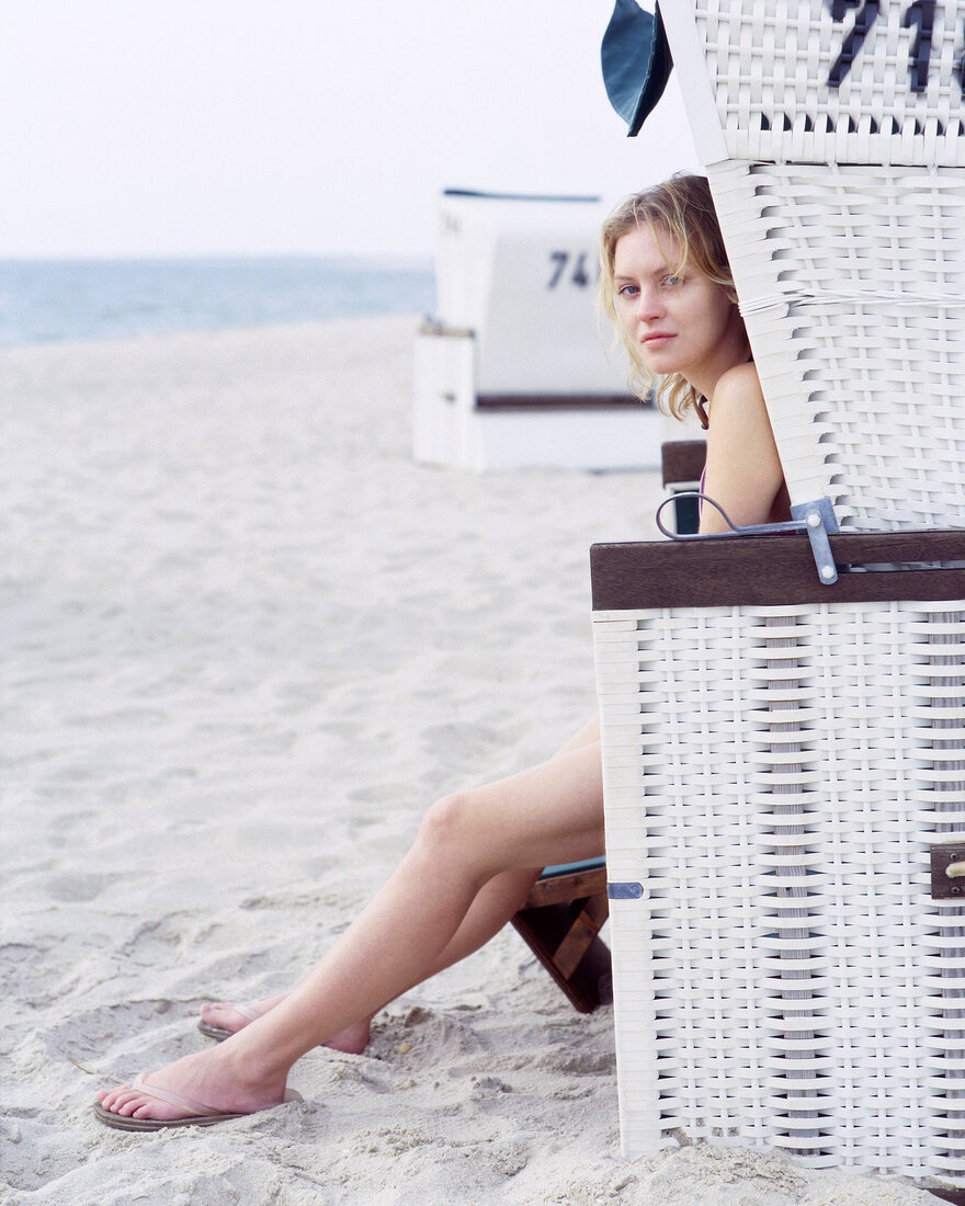 Blonde woman sitting on beach chair at West beach in Kampen, Sylt, Germany