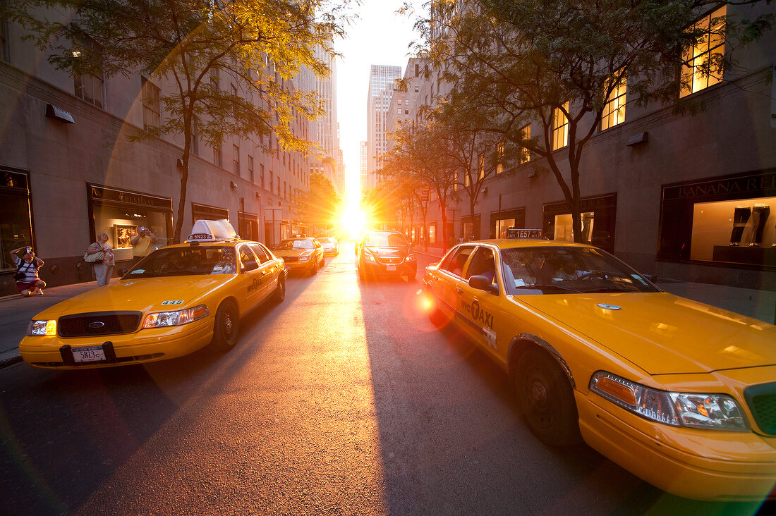 Yellow cabs on street at sunset in New York, USA