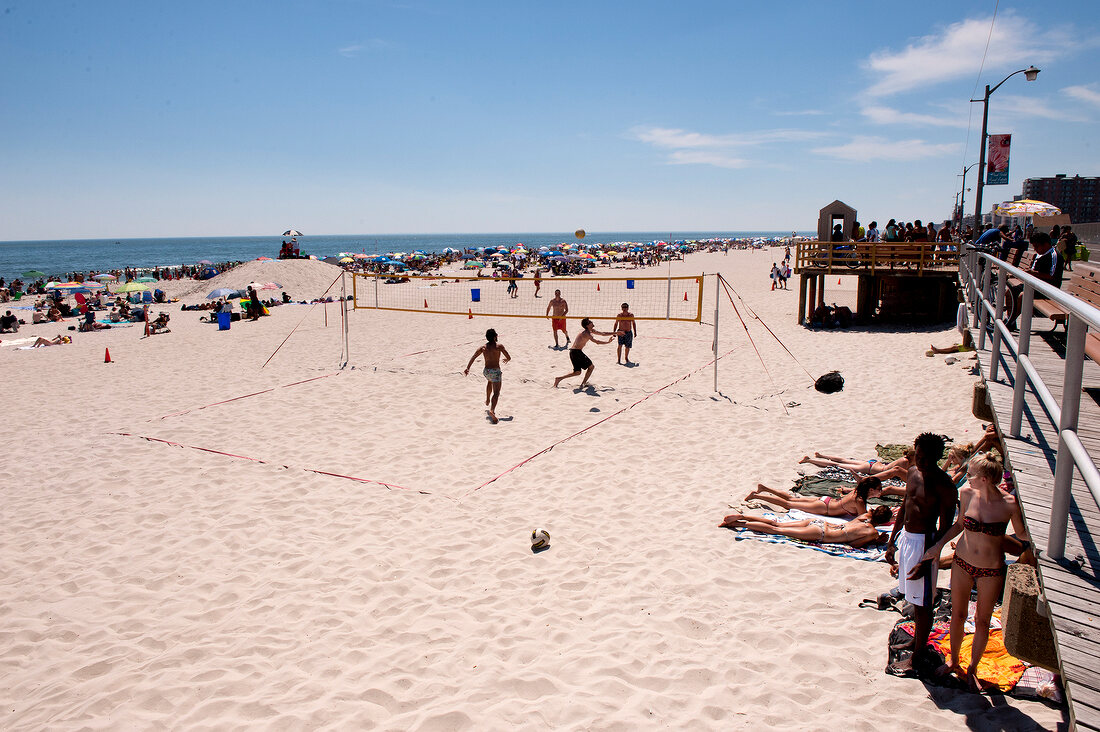 People playing volleyball on beach, New York, USA