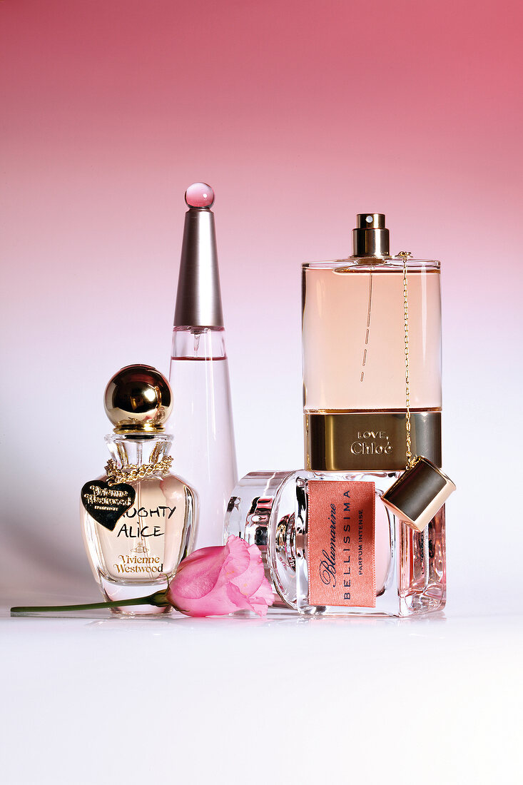 Close-up of various perfume bottles against pink background