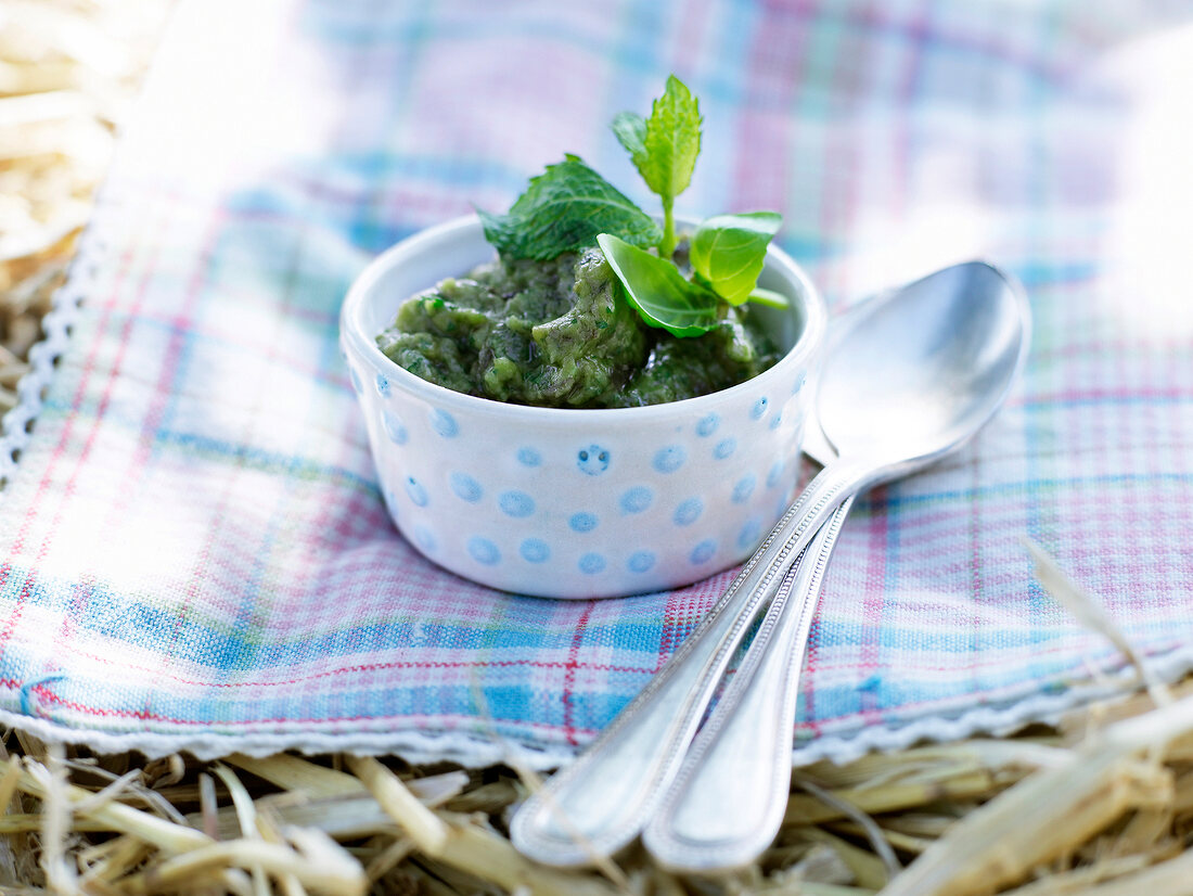 Bowl of green aubergine garnished with herbs