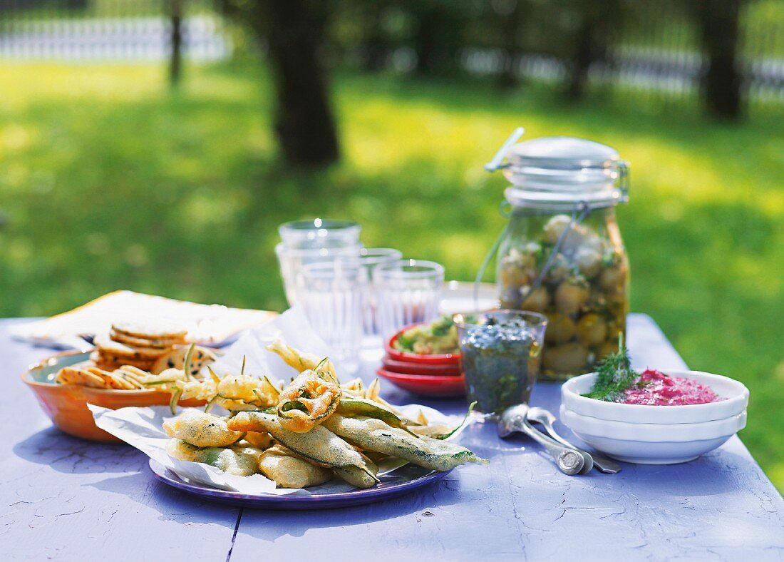 Various side dishes for a summer party on a table in a garden