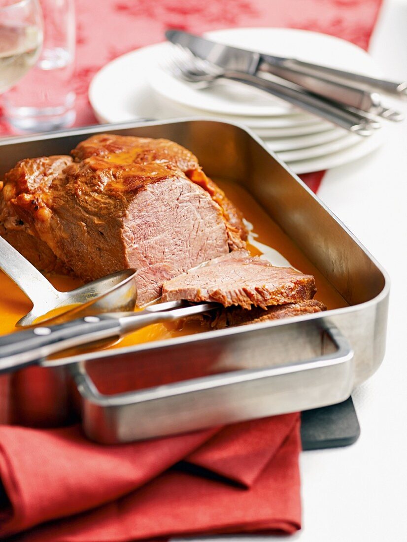 Roast veal with coriander sauce in a roasting tin