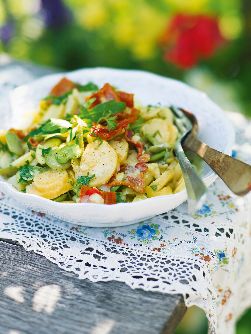 Potato salad with broad beans and arugula in bowl