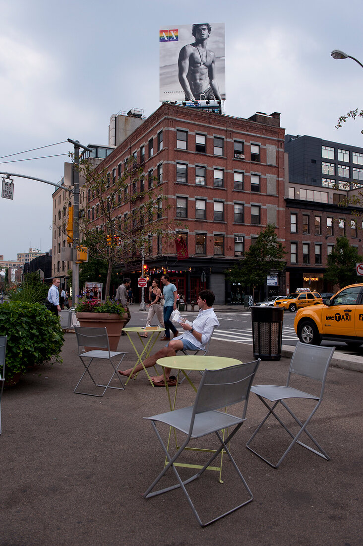 People walking and sitting beside road in New York, USA