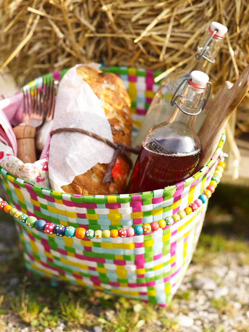 Sommerküche, Picknickkorb mit Brot und Sirup in Flaschen